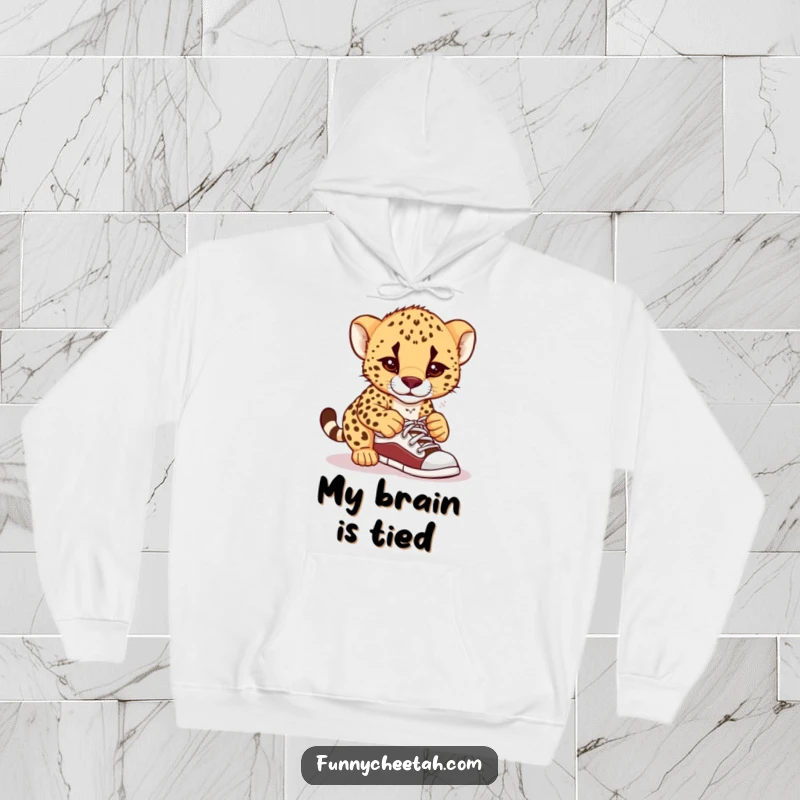 Funny hoodie depicting a cheetah cub in a comical knot of confusion while attempting to tie its shoelaces, perfect for cozy laughs.